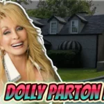 Dolly Parton house - Country music star standing in front of her Brentwood Tennessee estate with black exterior and dormer windows