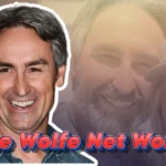 Mike Wolfe net worth featured image showing the American Pickers star smiling in denim shirt with red text overlay