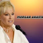 Lorrie Morgan performing with microphone, mother of Morgan Anastasia Gaddis, wearing white outfit with pearl necklace