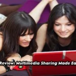 Two women happily watching content on a red laptop, representing easy and secure multimedia sharing on erome.xom