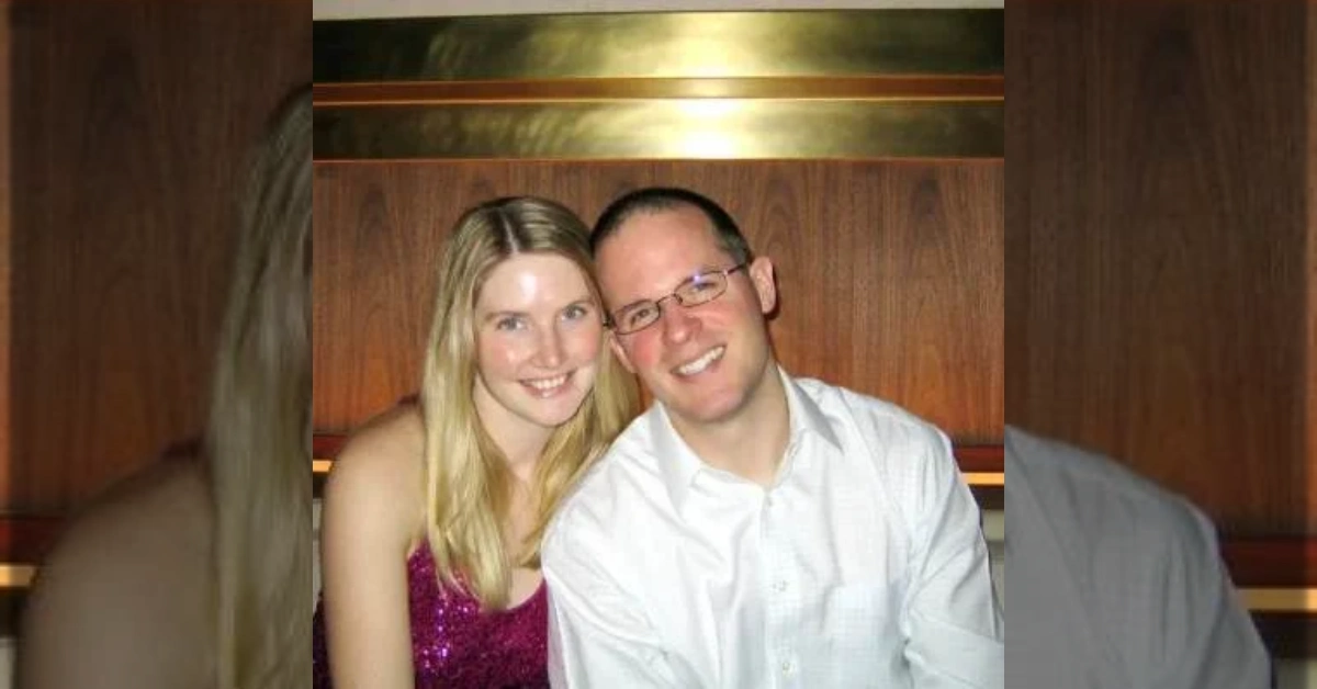 A smiling couple sitting closely together in a warm wooden interior.