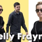 Kelly Frayne walking outdoors with a companion, wearing sunglasses and a black outfit, captured in a casual street-style moment.