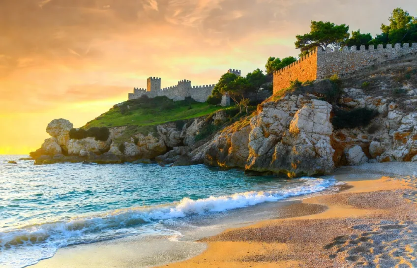 Stunning golden sand beach and historic castle overlooking turquoise sea in Merfez Turkey