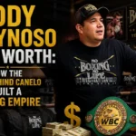 Eddy Reynoso standing in his boxing gym surrounded by WBC and WBO championship belts, wearing a No Boxing No Life shirt, with the article title Eddy Reynoso Net Worth: How the Man Behind Canelo Built a Boxing Empire