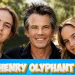 Timothy Olyphant posing outdoors with two young family members in a sunny setting with Henry Olyphant title text