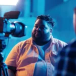 Professional video&a content creator directing filming session with camera equipment and blue lighting setup