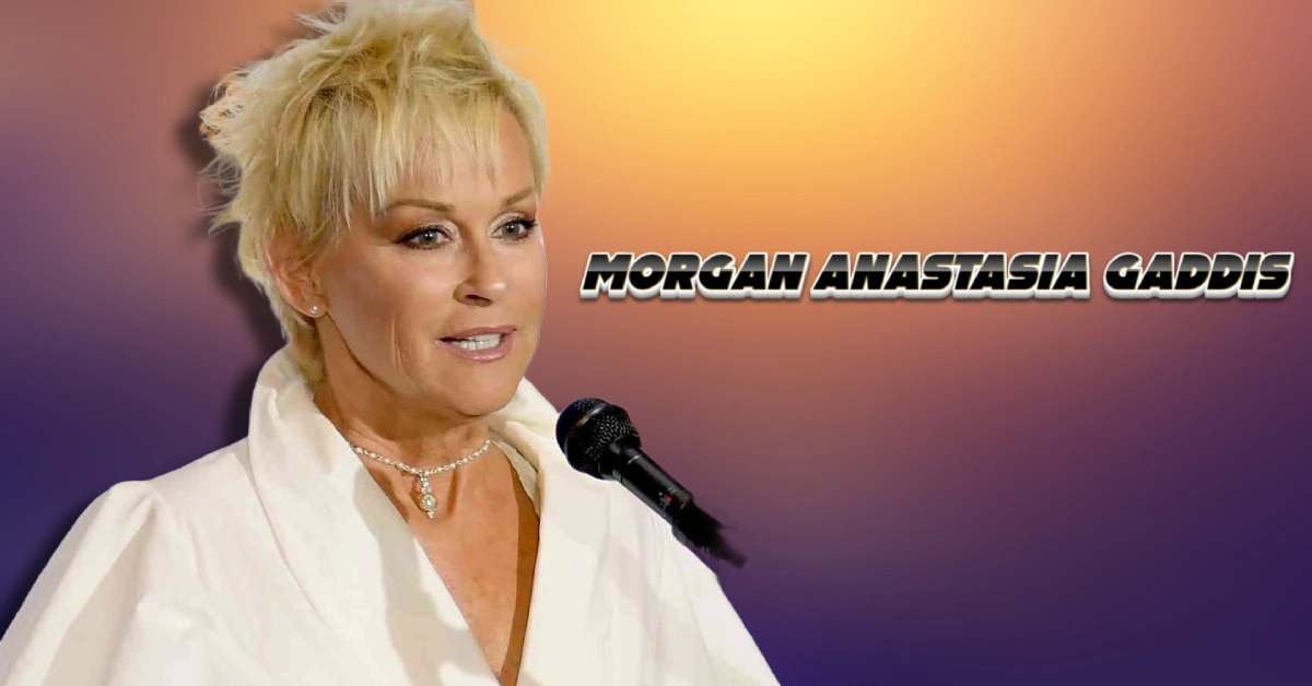 Lorrie Morgan performing with microphone, mother of Morgan Anastasia Gaddis, wearing white outfit with pearl necklace